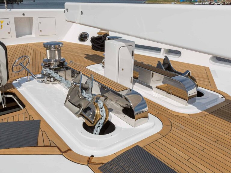 Marine anchor windlass system with polished stainless steel components on a boat deck.