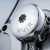 Precision-machined metal component with "MUIR" engraved, highlighting engineering craftsmanship.