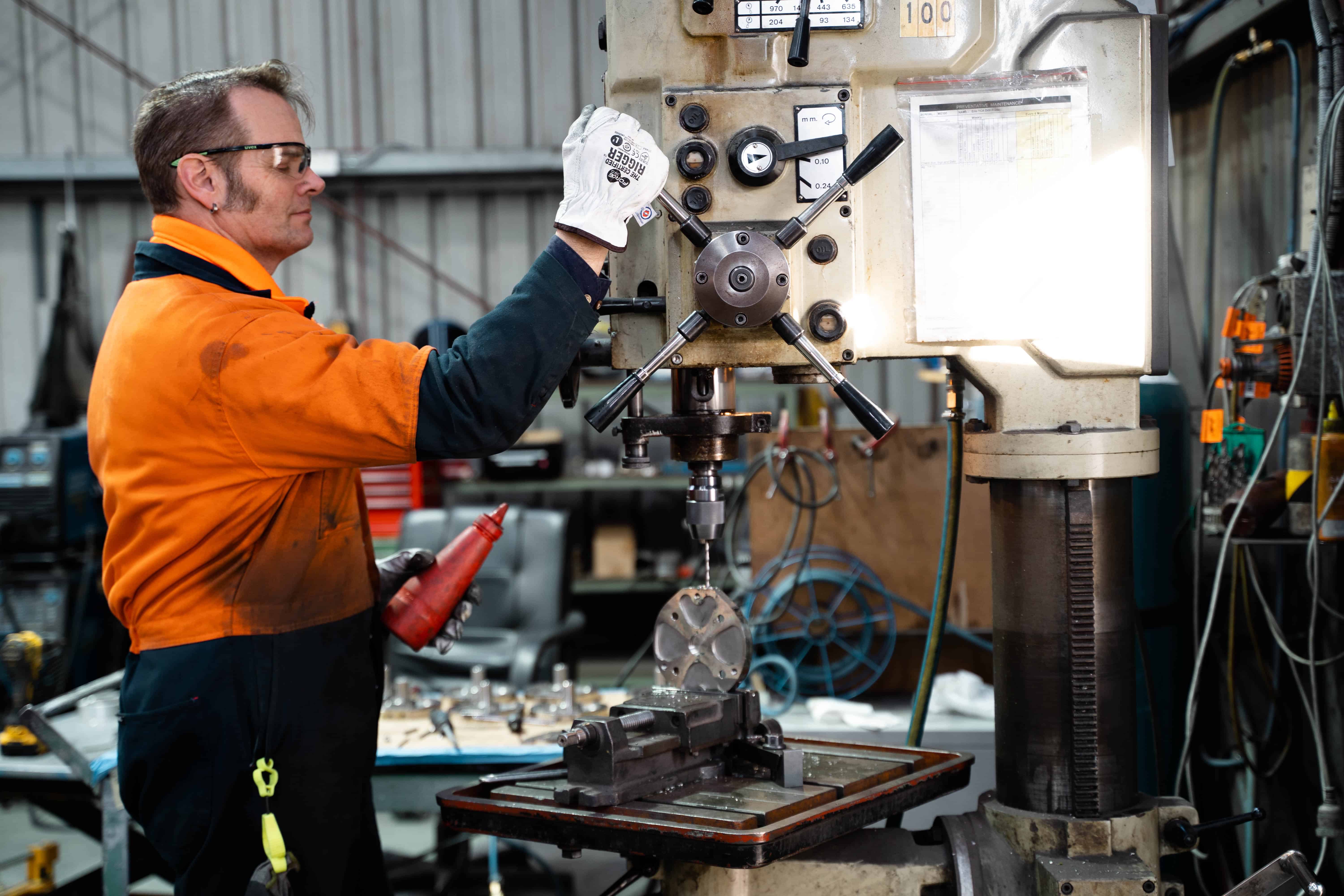 Precision engineering technician operating a milling machine in a workshop.